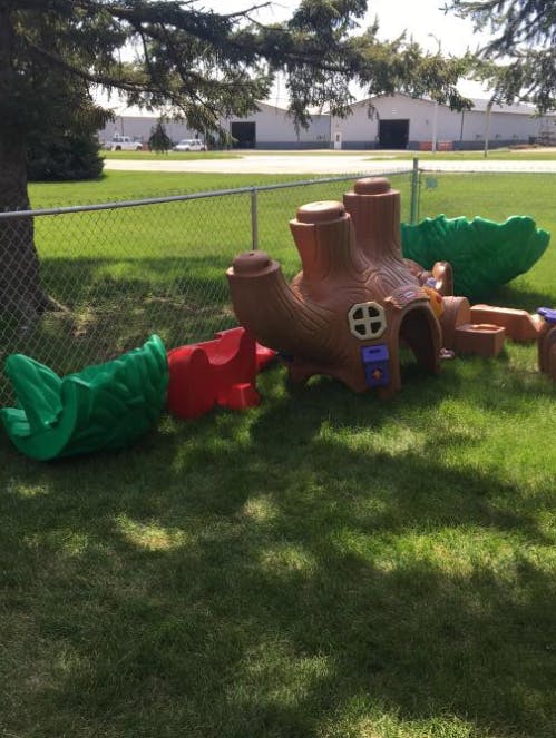 Outdoor playground equipment shaped like a tree trunk and leaves