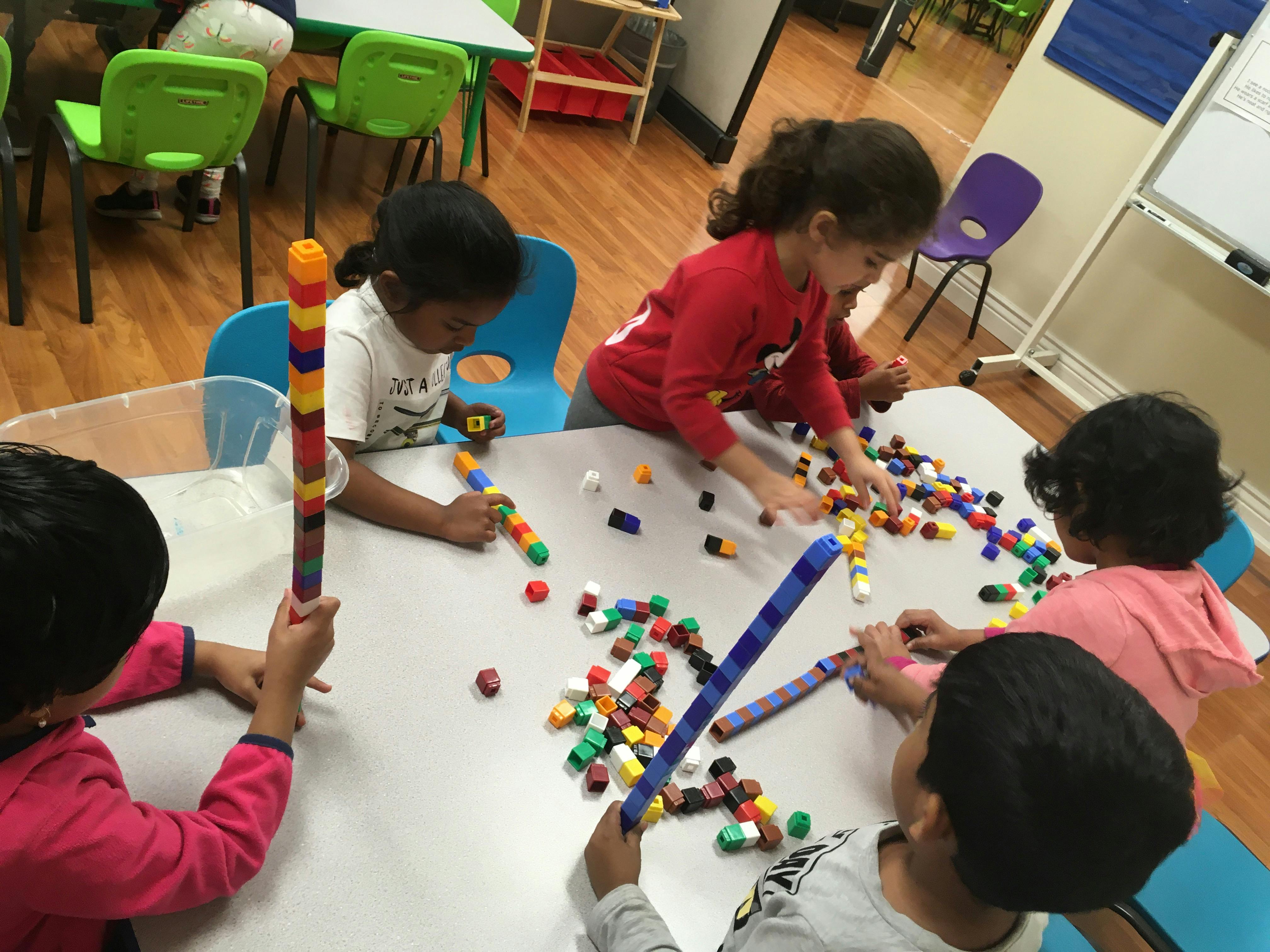 Children playing with colorful building blocks at a table