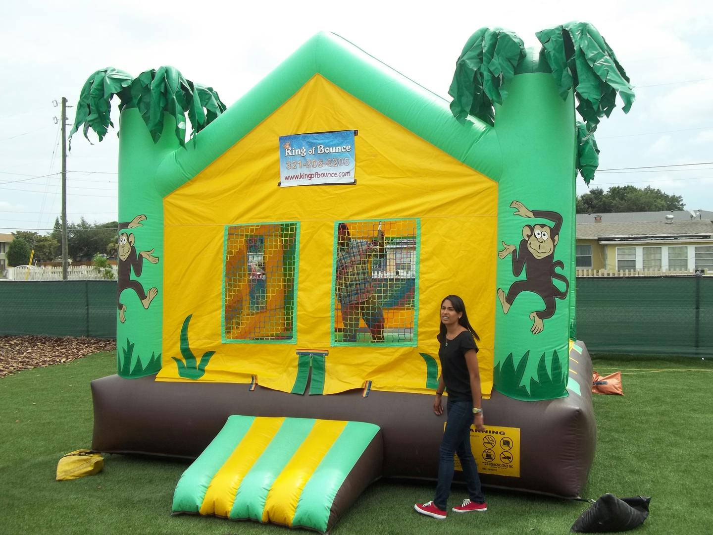 Person standing next to an inflatable bounce house