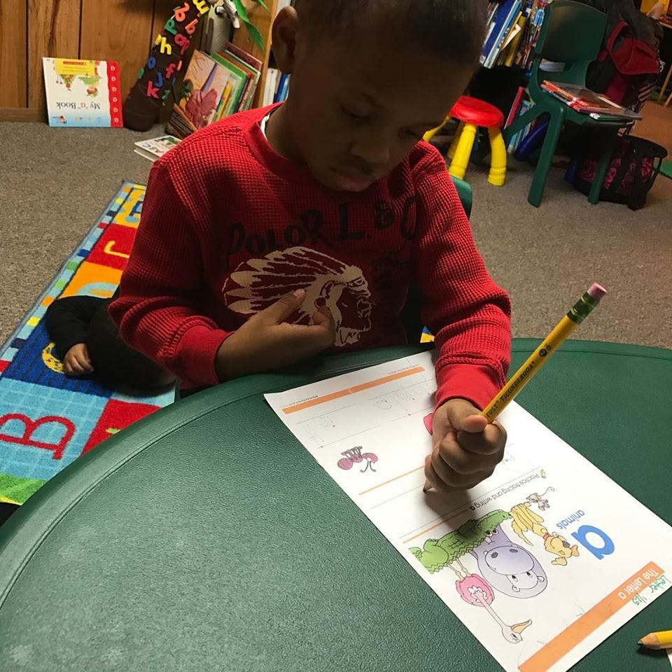 Child drawing on paper with a pencil