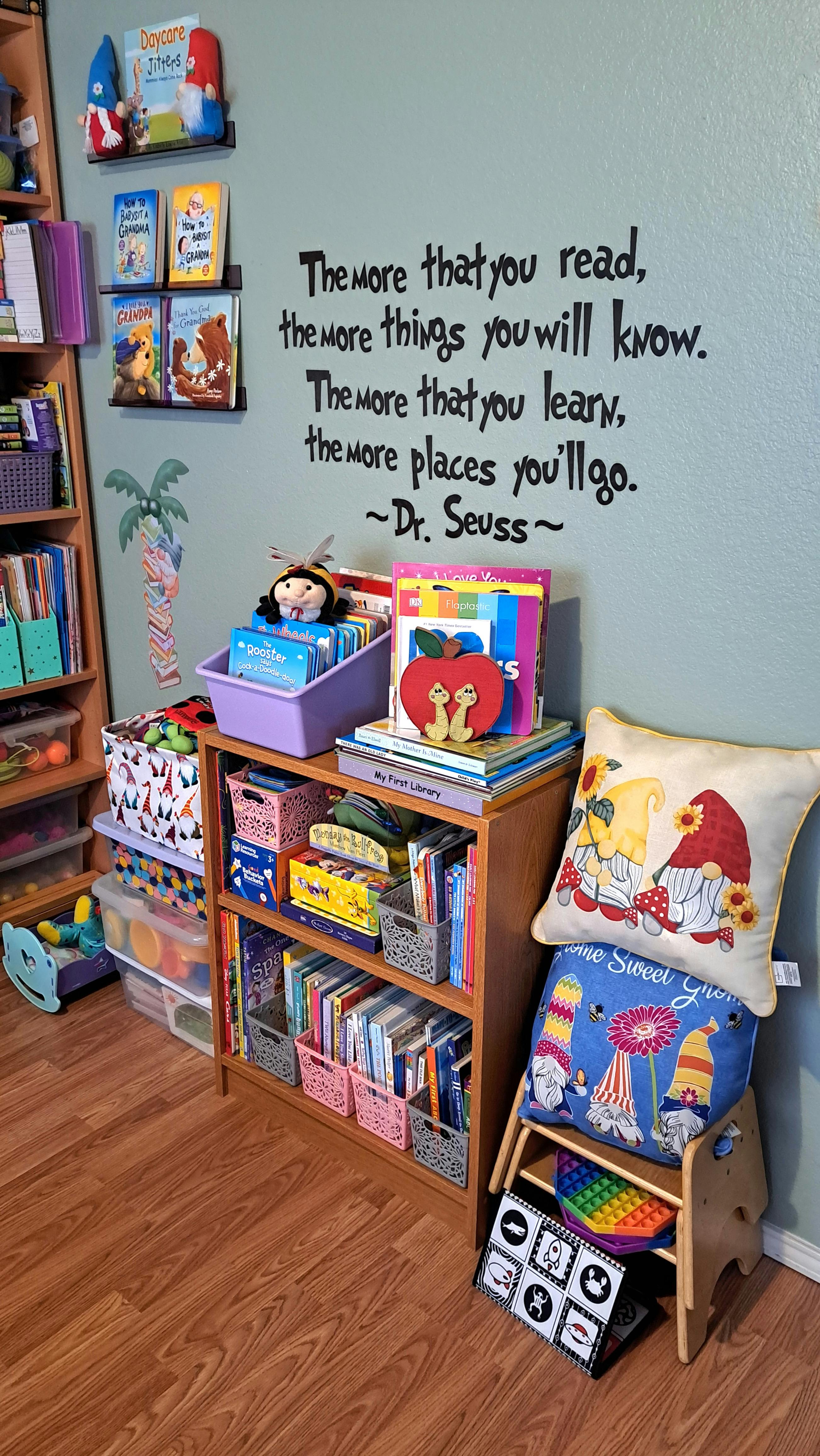 Children's books and toys on shelves with a Dr. Seuss quote on the wall