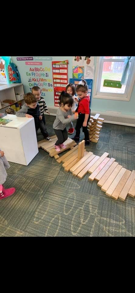 Children playing on wooden blocks in a classroom