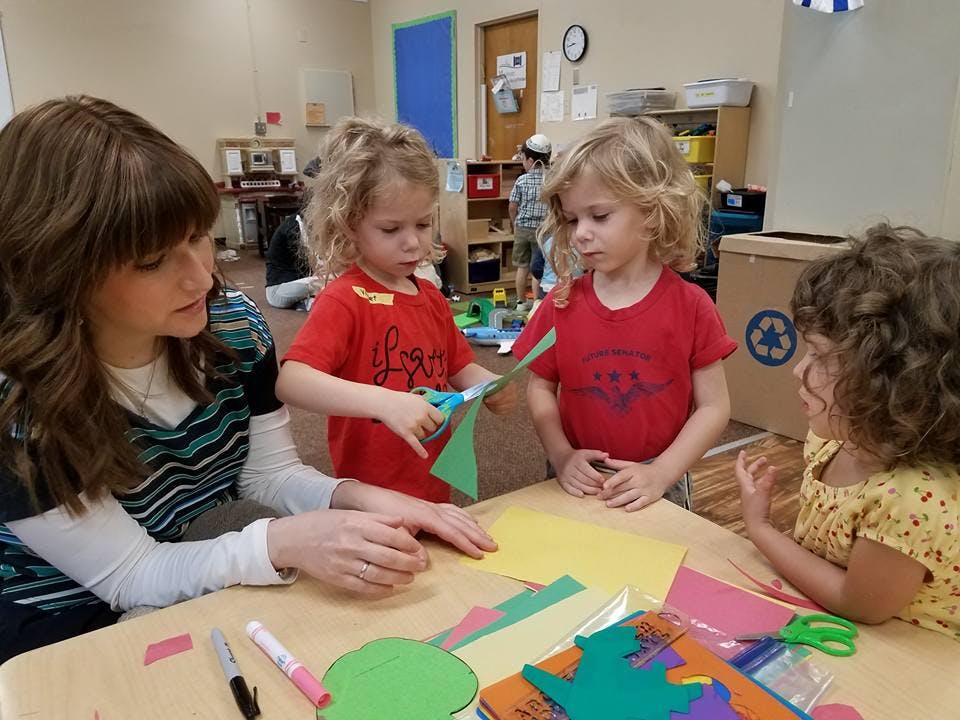 Adult and three children doing crafts at a table