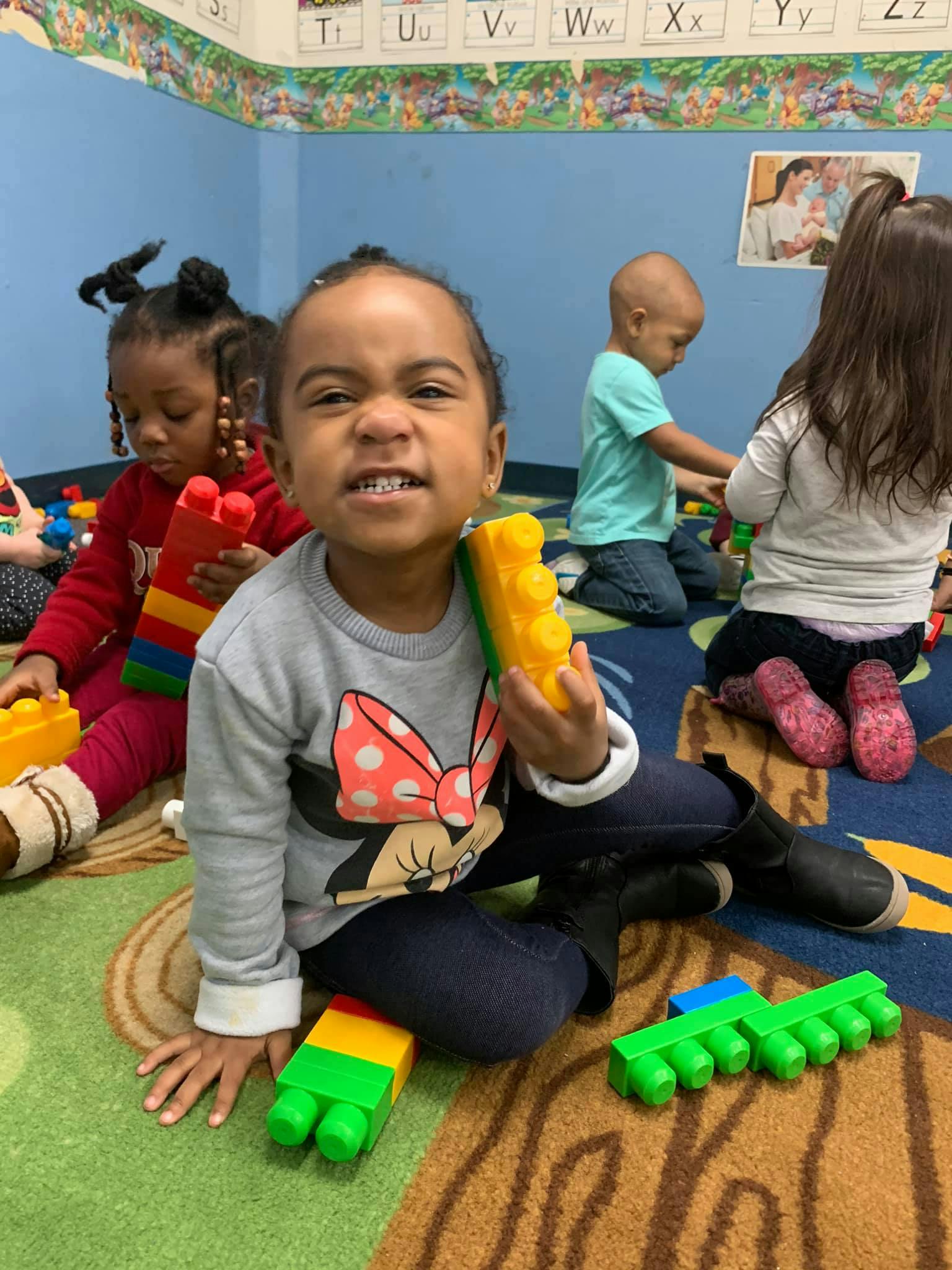 Child playing with large building blocks in a classroom