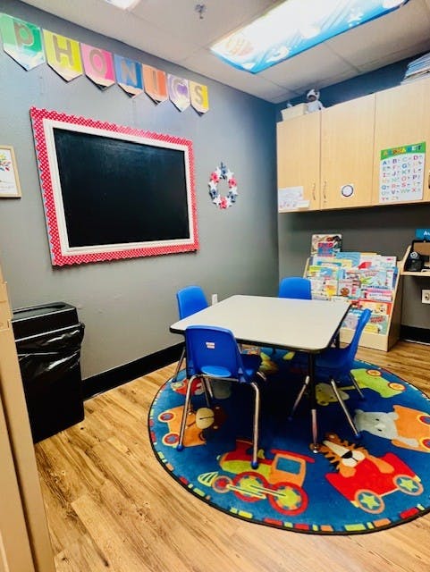 Classroom with a small table and chairs on a round rug with toy patterns