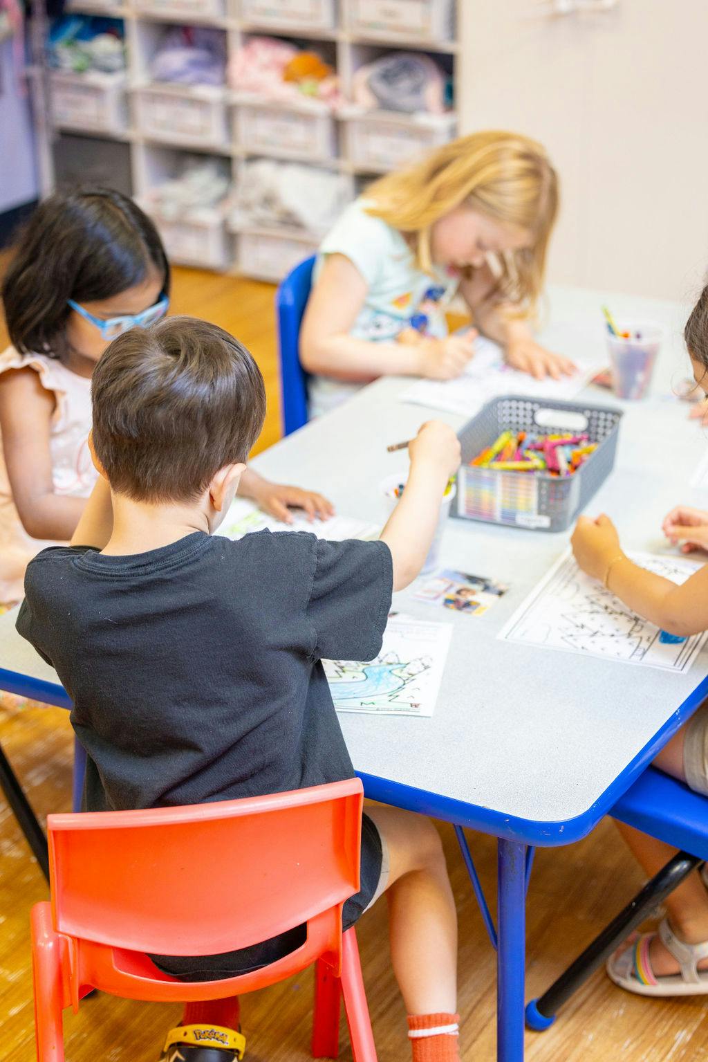 Children drawing at a table in a classroom