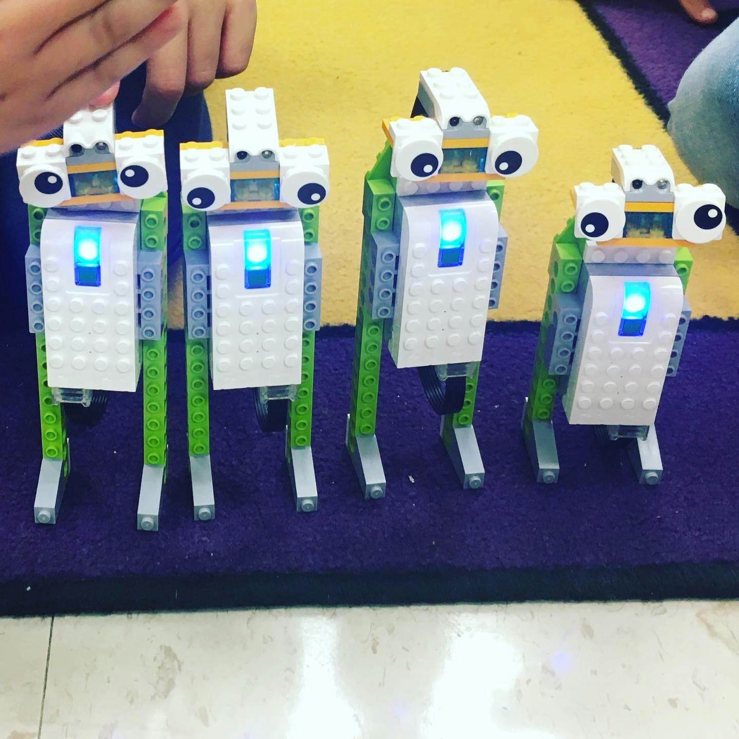 Four Lego robots with glowing blue lights