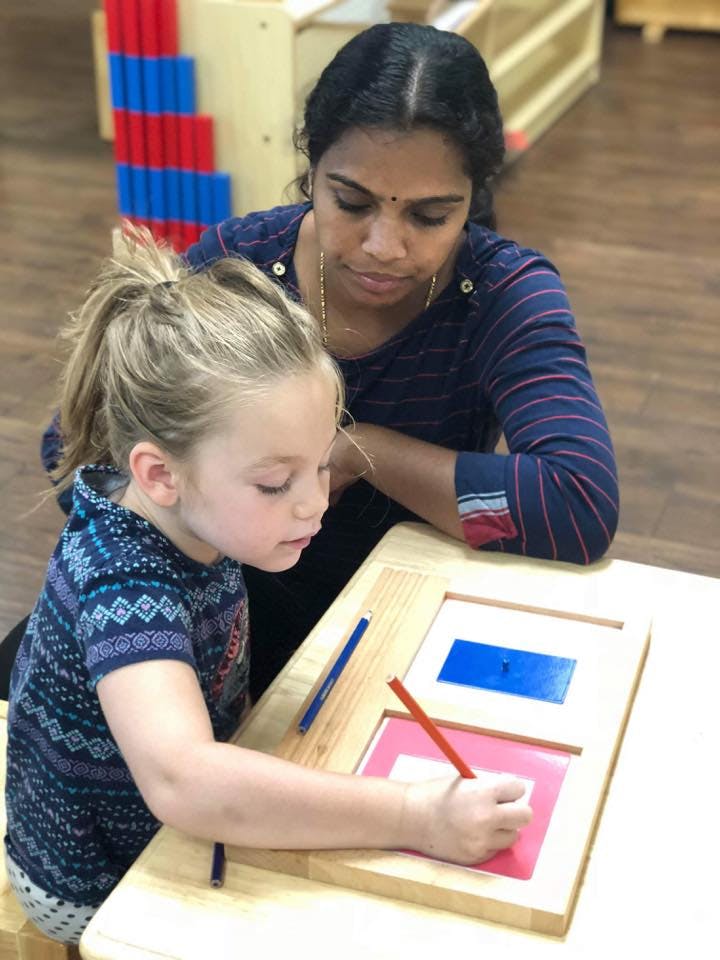 Adult and child drawing with pencils at a table