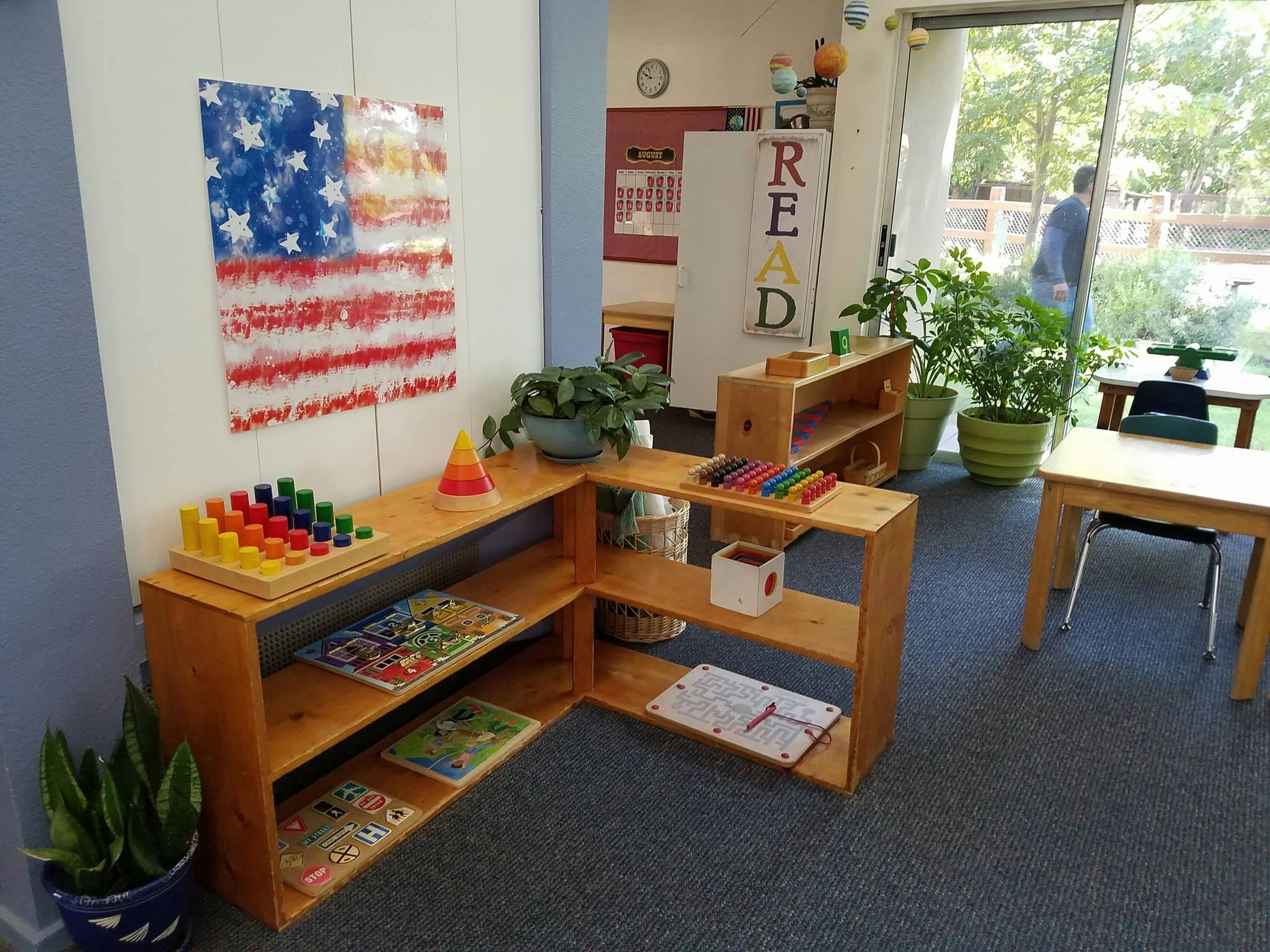 Classroom with wooden shelves, learning materials, and a window