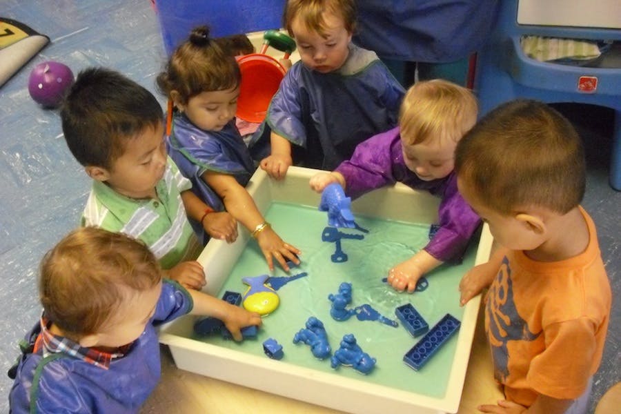 Children playing with toys in a water table
