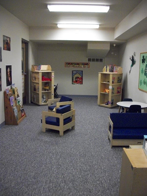 Children's play area with small chairs, tables, and bookshelves