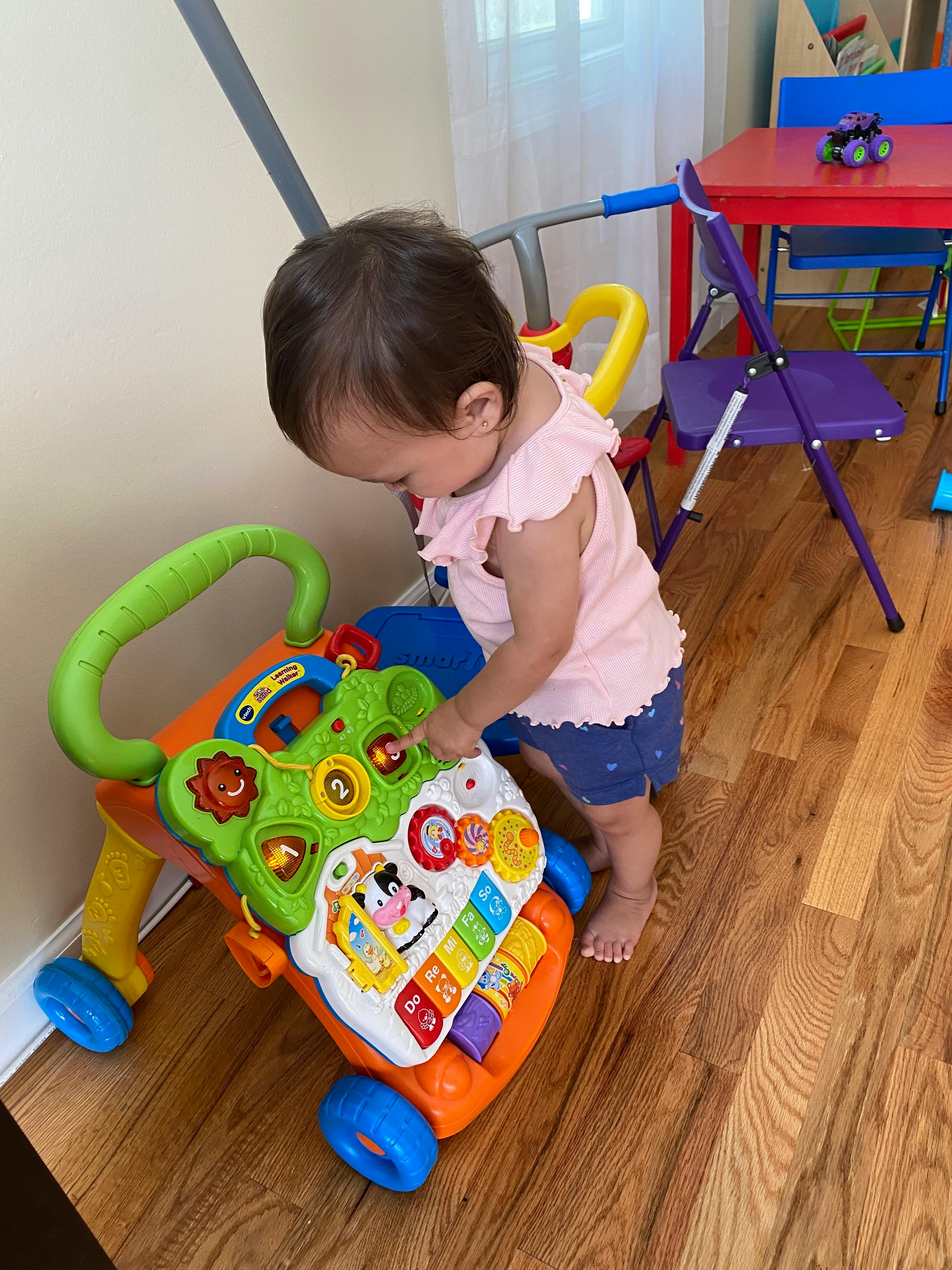 Child playing with a colorful activity walker
