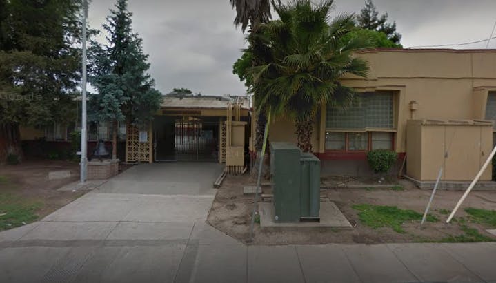 Driveway leading to a building with trees and utility boxes