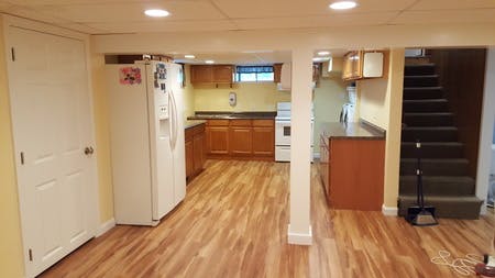 Basement kitchen with wood flooring and white appliances