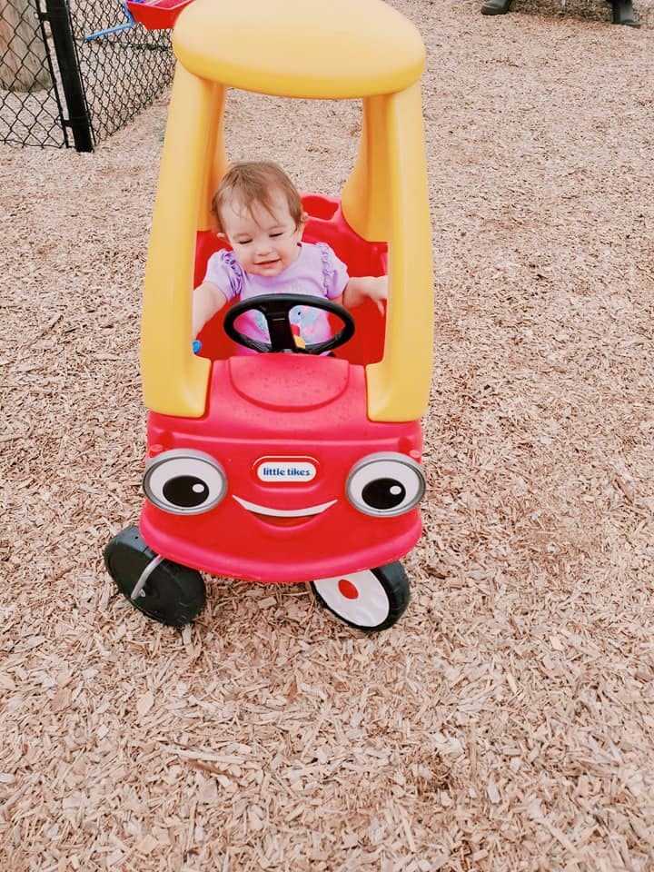 Child in a red and yellow toy car