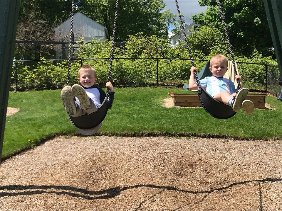 Two children on swings on a playground