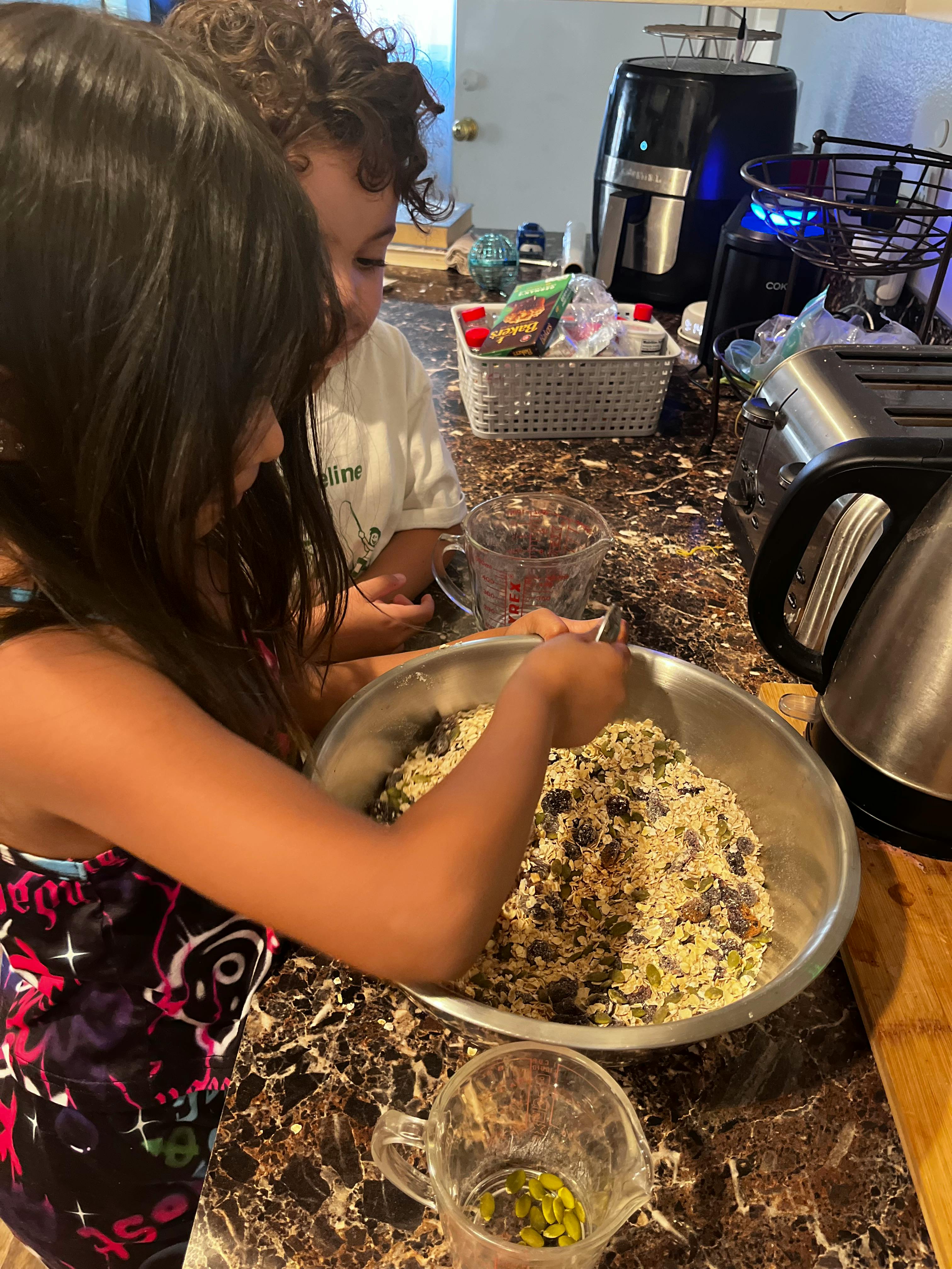 Child mixing ingredients in a bowl in a kitchen