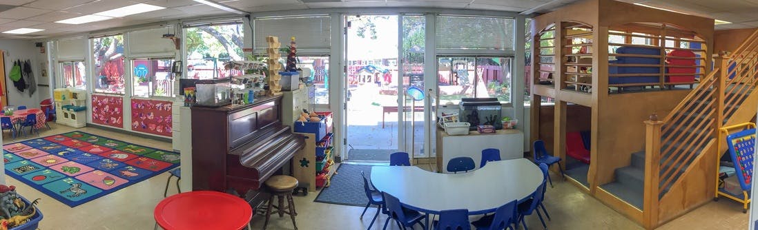 Playroom with colorful rug, piano, and wooden play structure