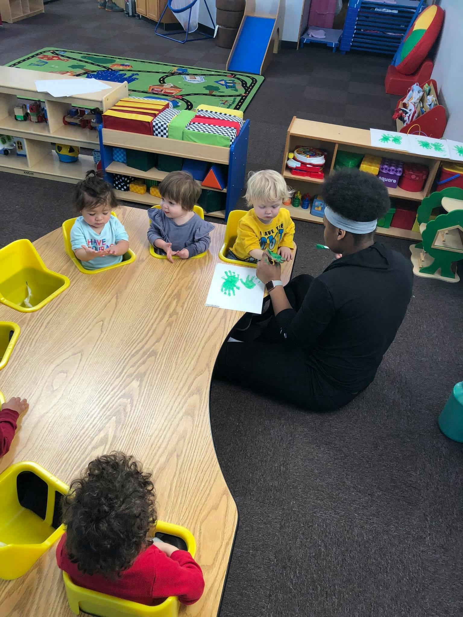 Adult and three children at a table with a drawing