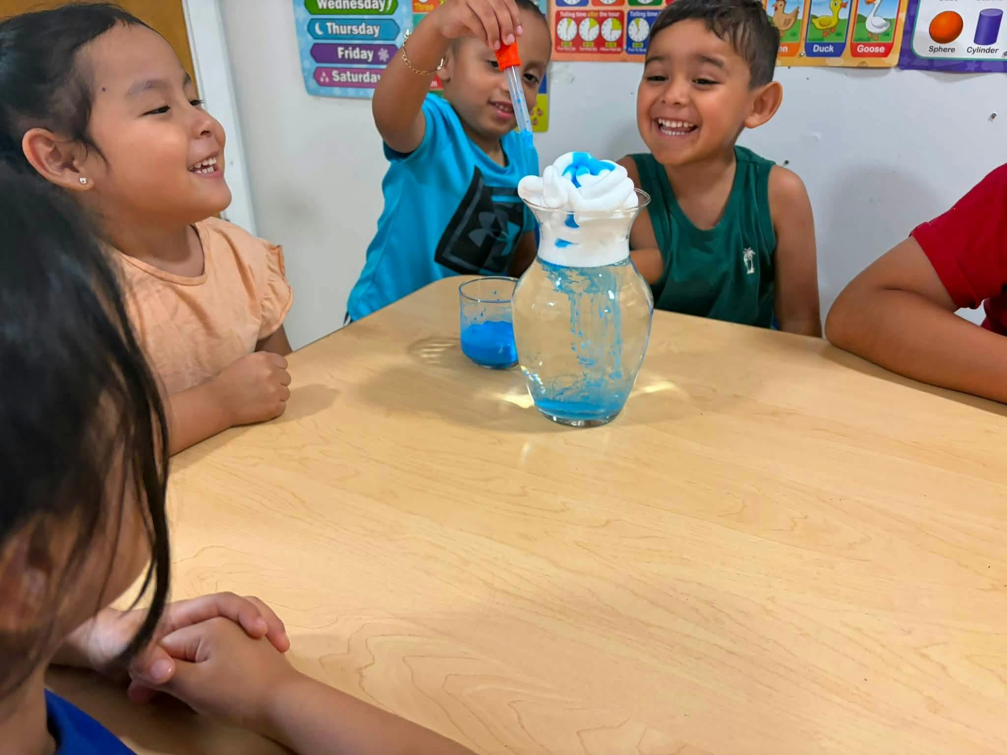 Children conducting a science experiment with shaving cream and liquid in a vase