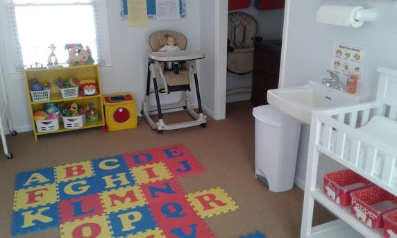 Child's room with alphabet mat, high chair, and changing station