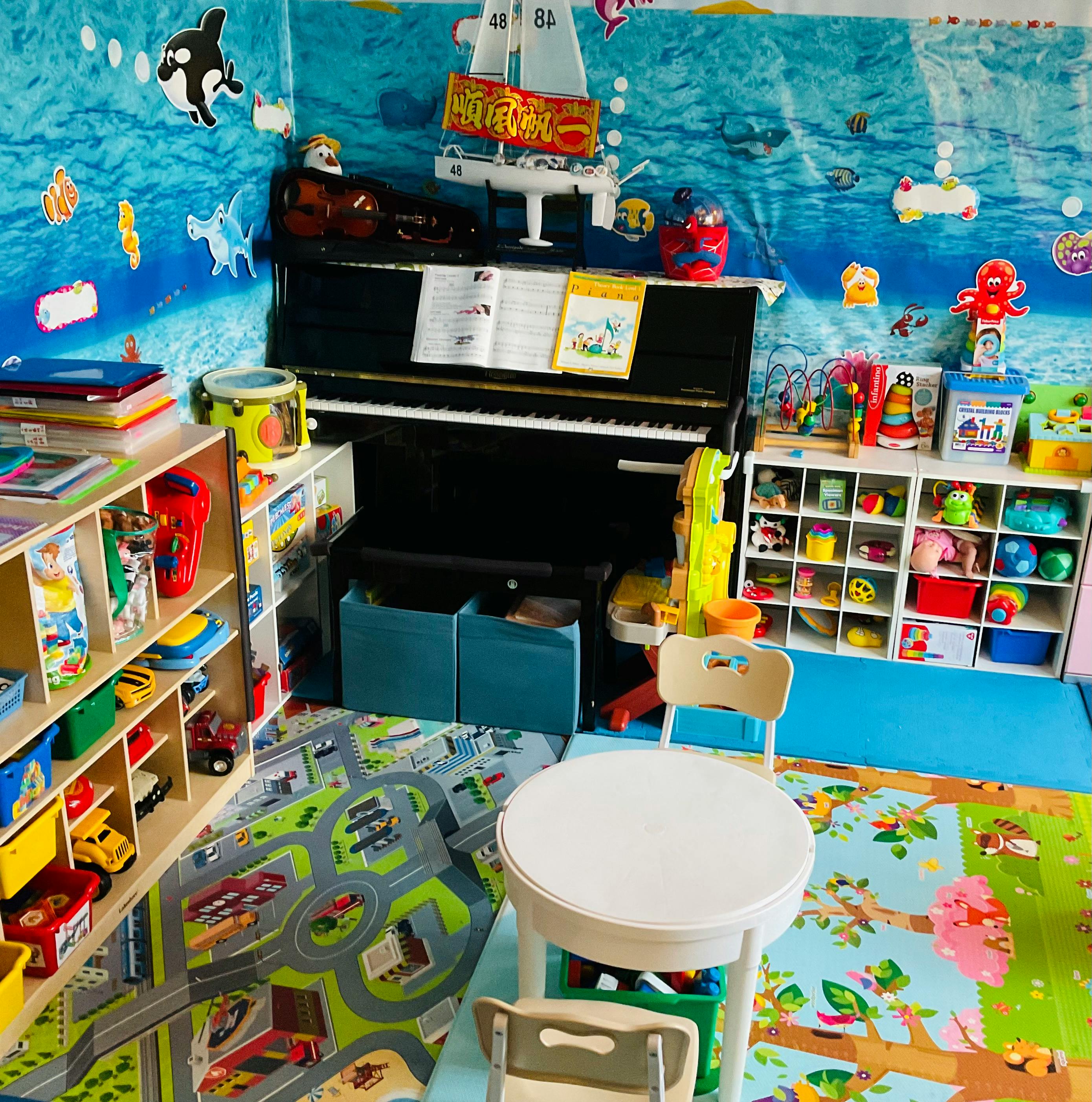 Playroom with a piano, shelves of toys, and a small table with chairs