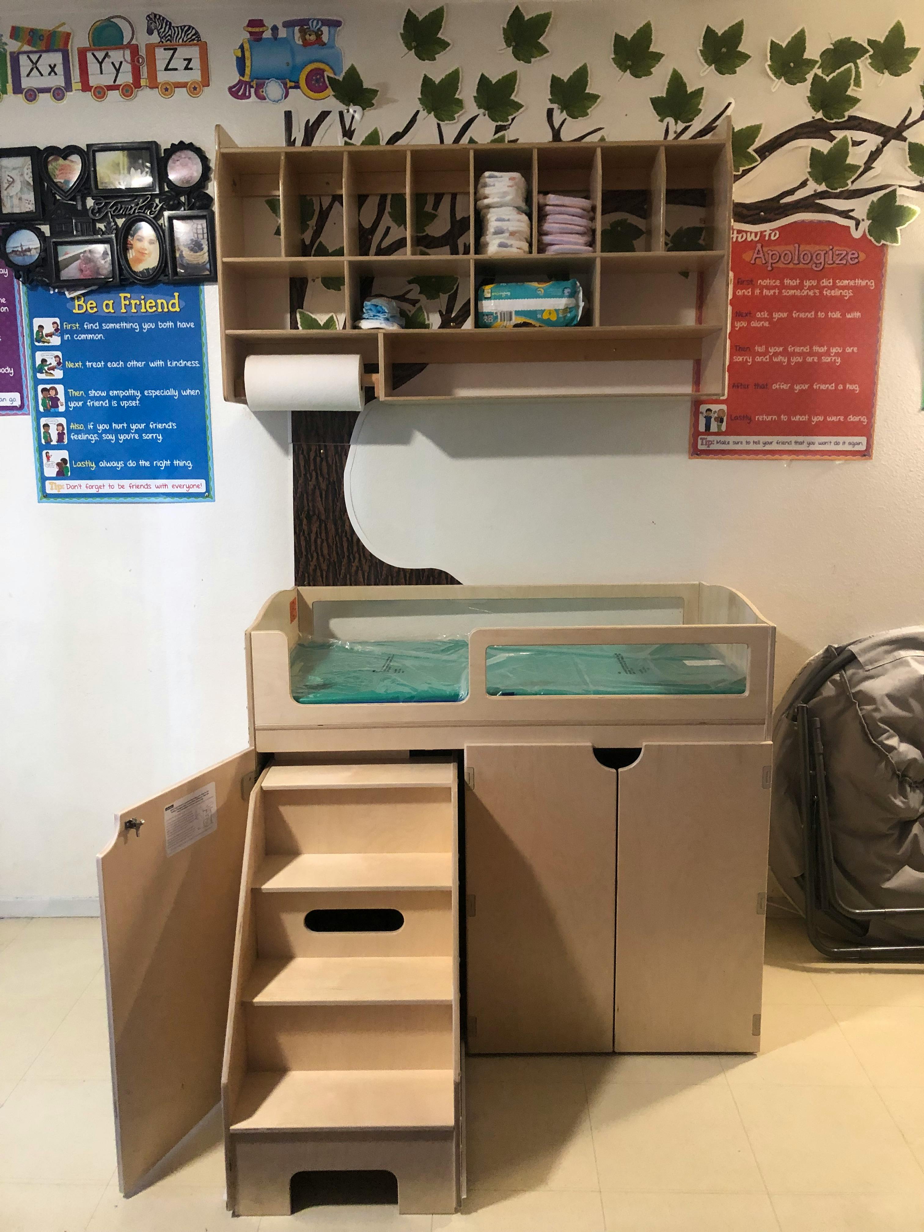 Changing table with steps and storage shelves above
