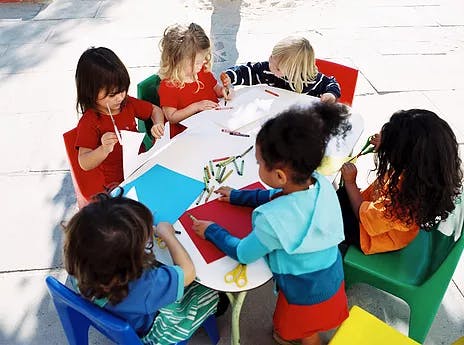 Children sitting around a table doing crafts