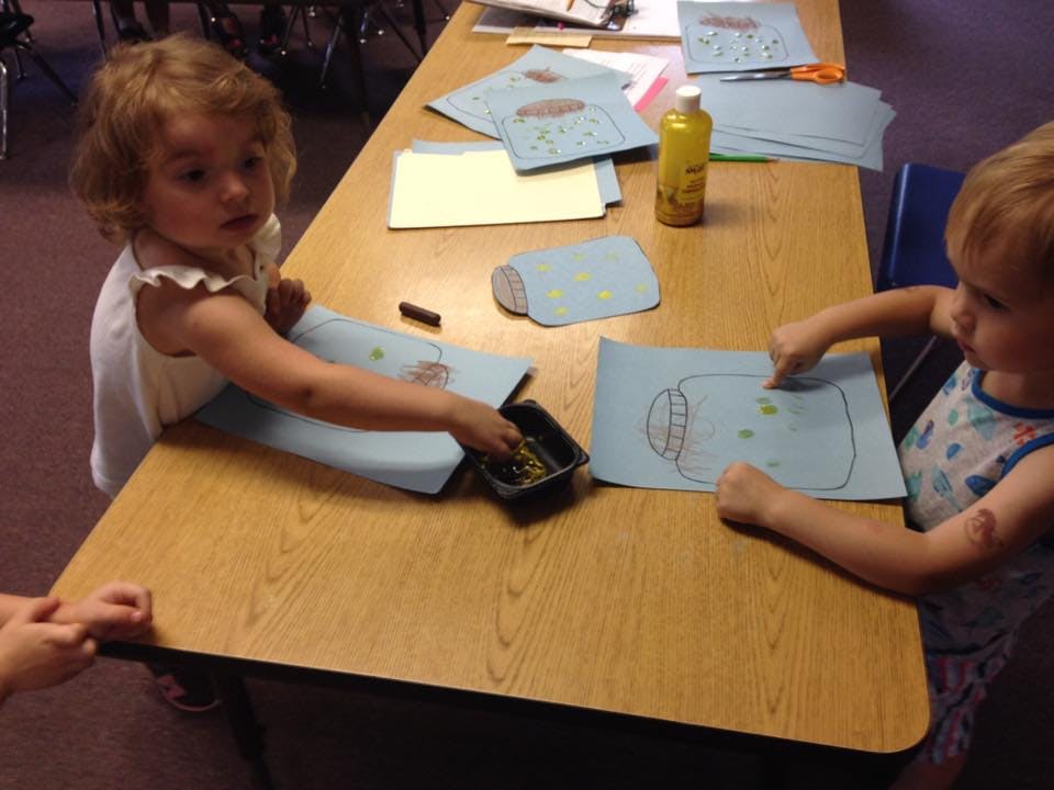 Two children doing an art project at a table