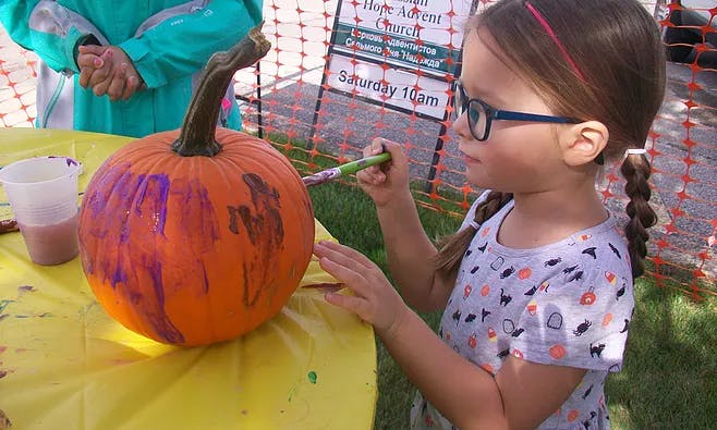 Child painting a pumpkin