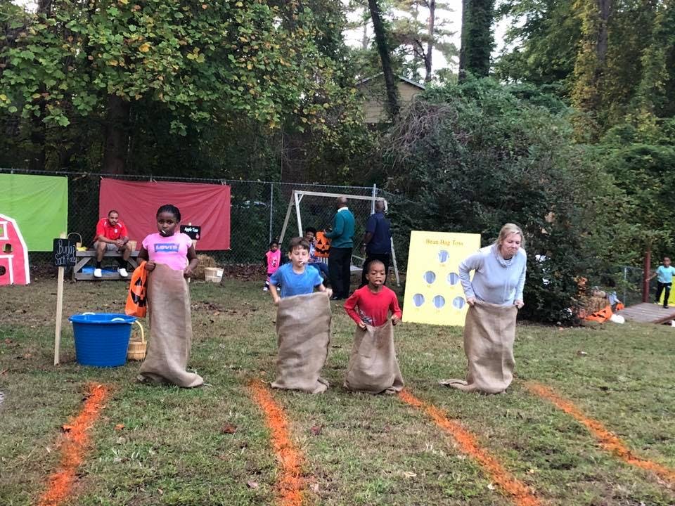 Children and an adult in a sack race outdoors