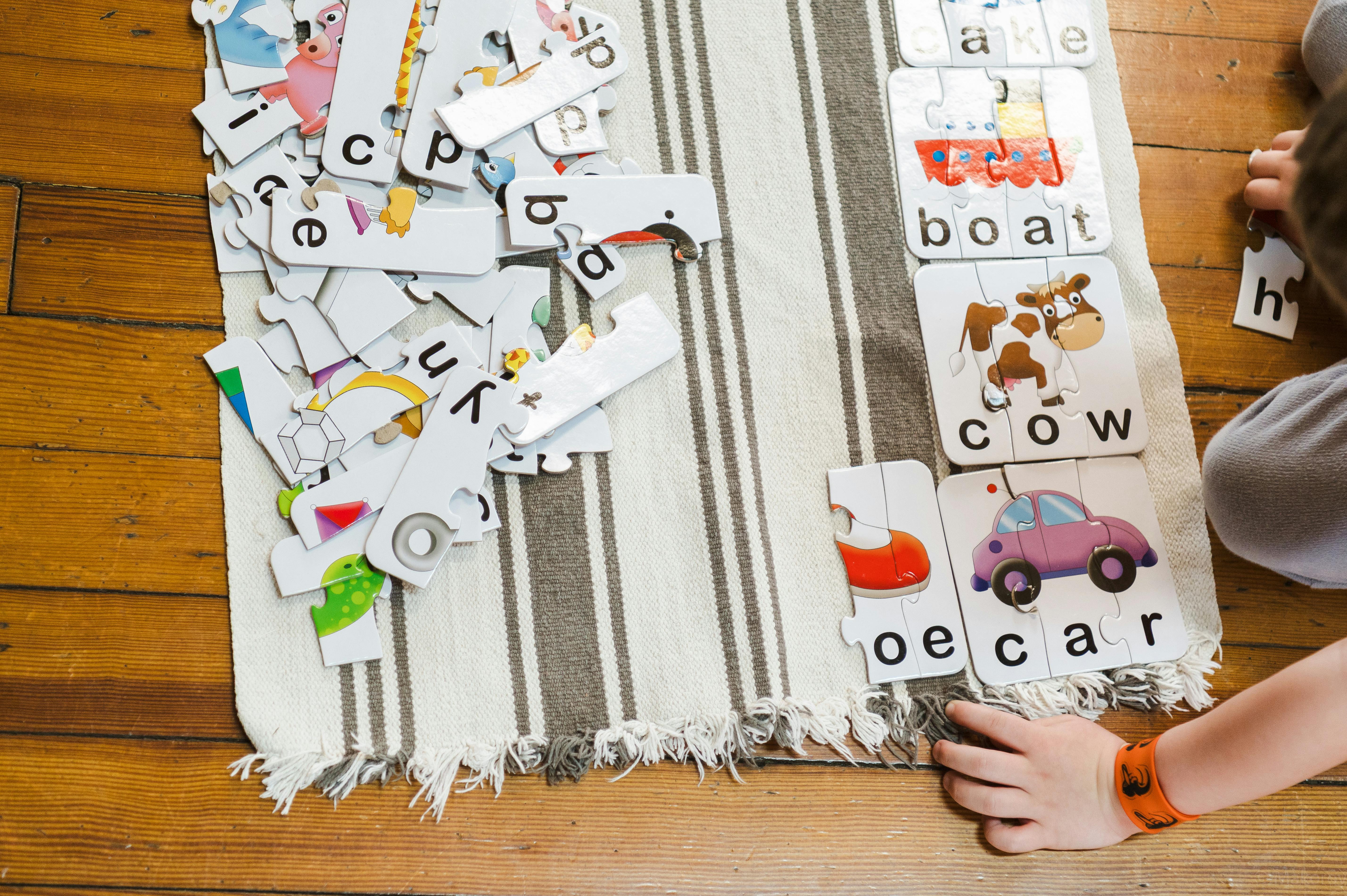 Child playing with alphabet and word puzzles on puzzle pieces