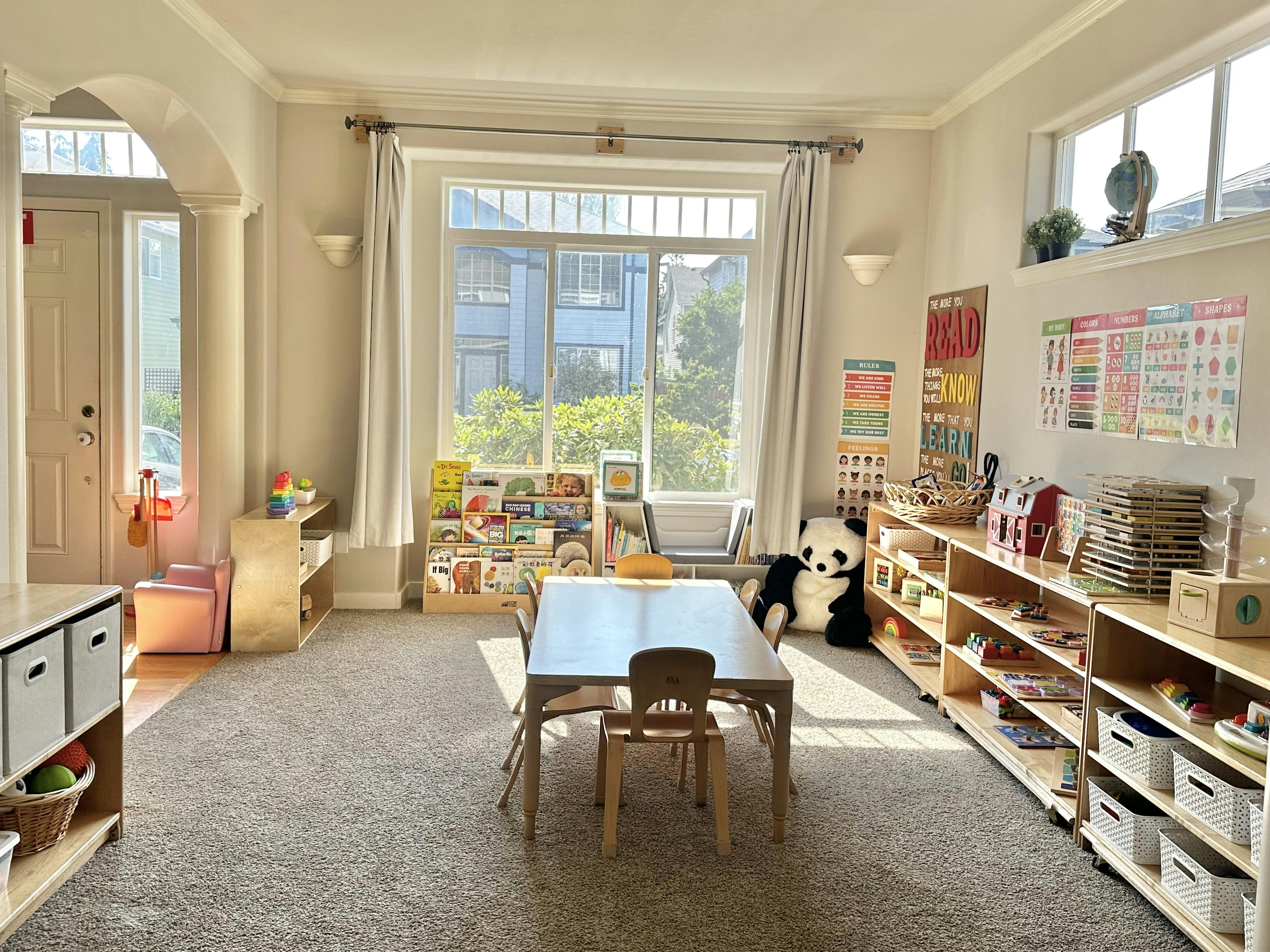Child learning room with table, chairs, bookshelves, and educational posters
