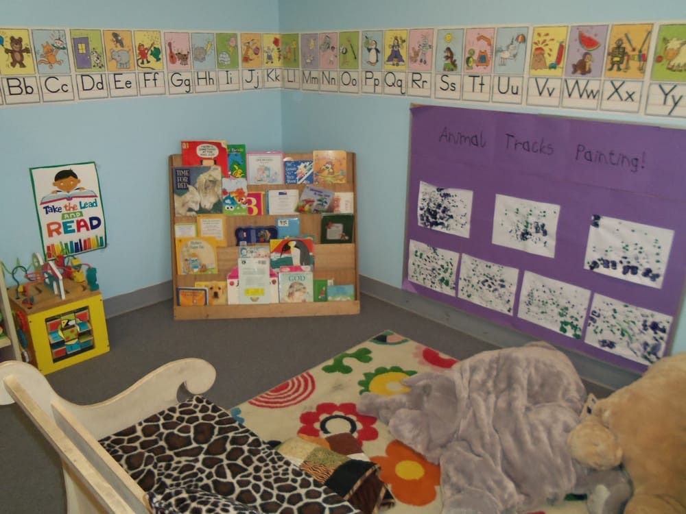 Children's classroom with alphabet border, bookshelf, and purple display board