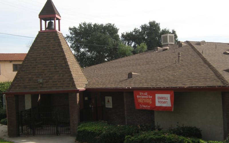 Building with a small bell tower and a red banner that says "Enroll Today!"