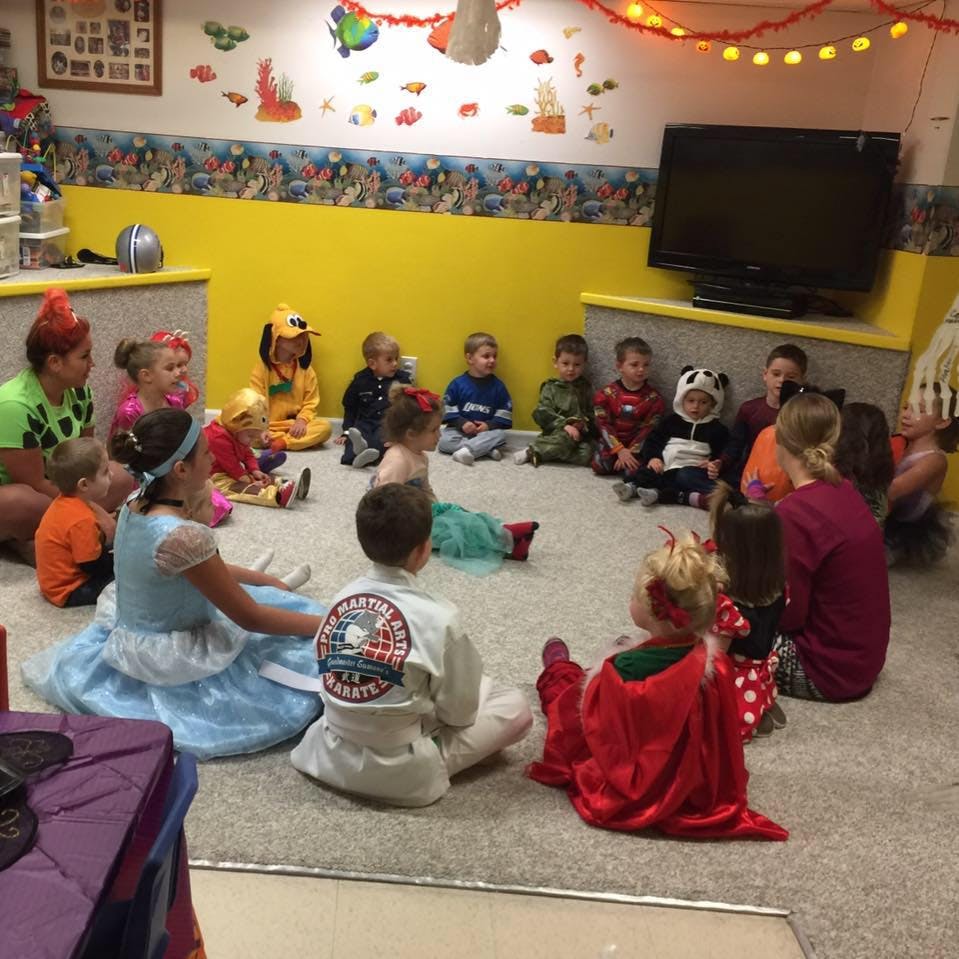 Children and adults sitting in a circle on the floor