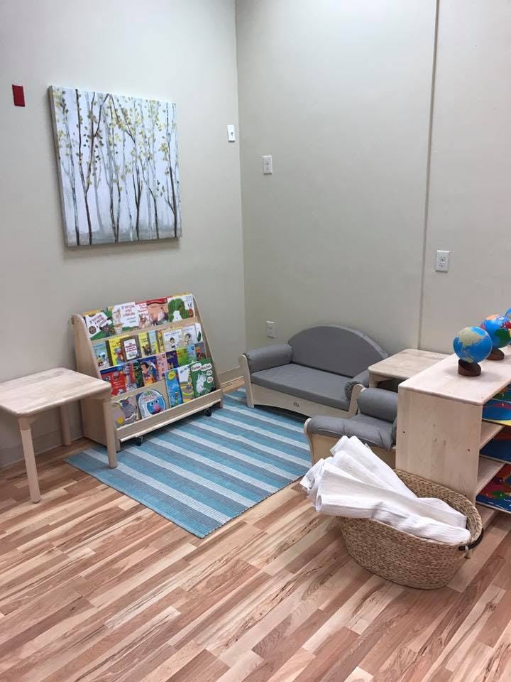 Children's reading nook with a bookshelf, small sofa, and rug