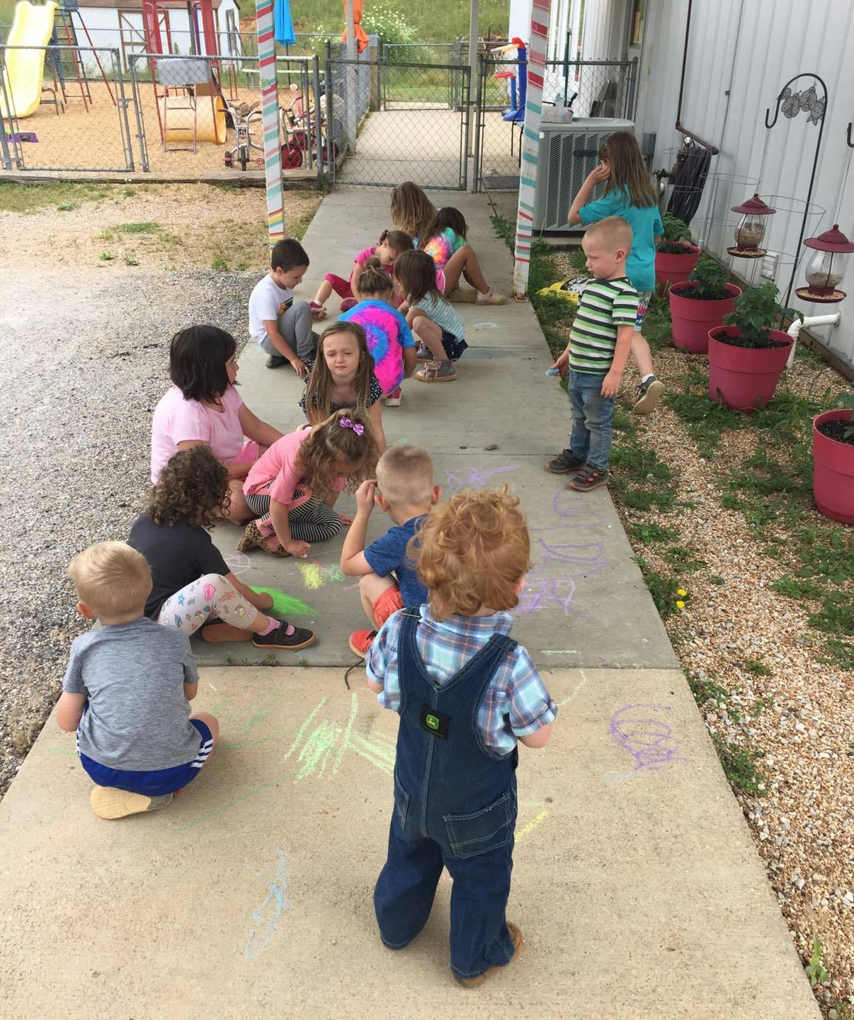Children drawing with chalk on a sidewalk