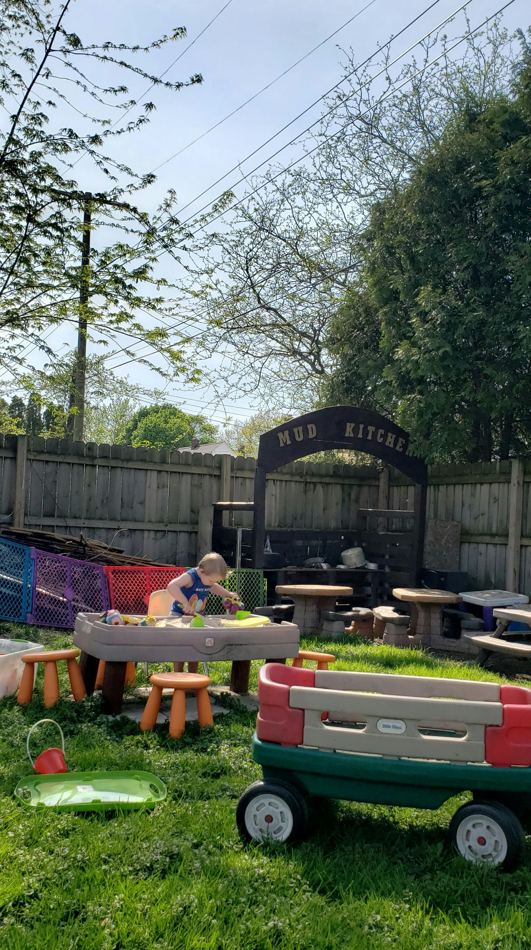 Child playing in a sand and water table in a backyard