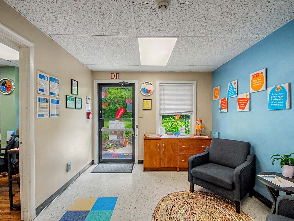 waiting room with a blue wall, armchairs, and an exit door