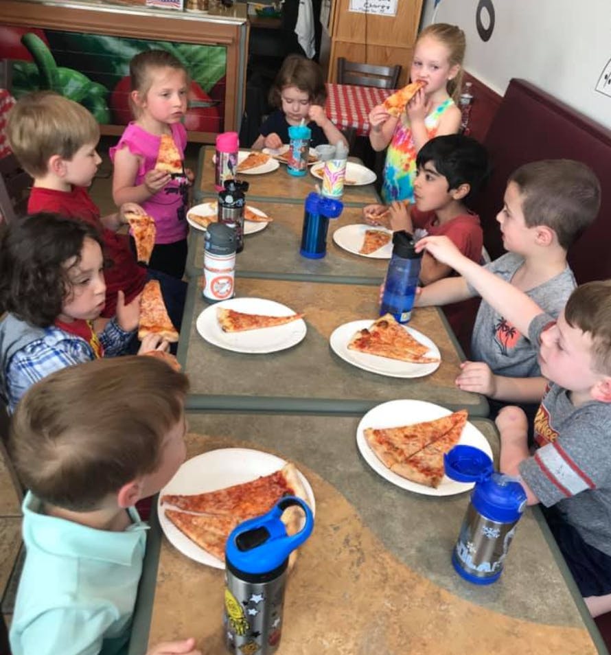 Children eating pizza at a table