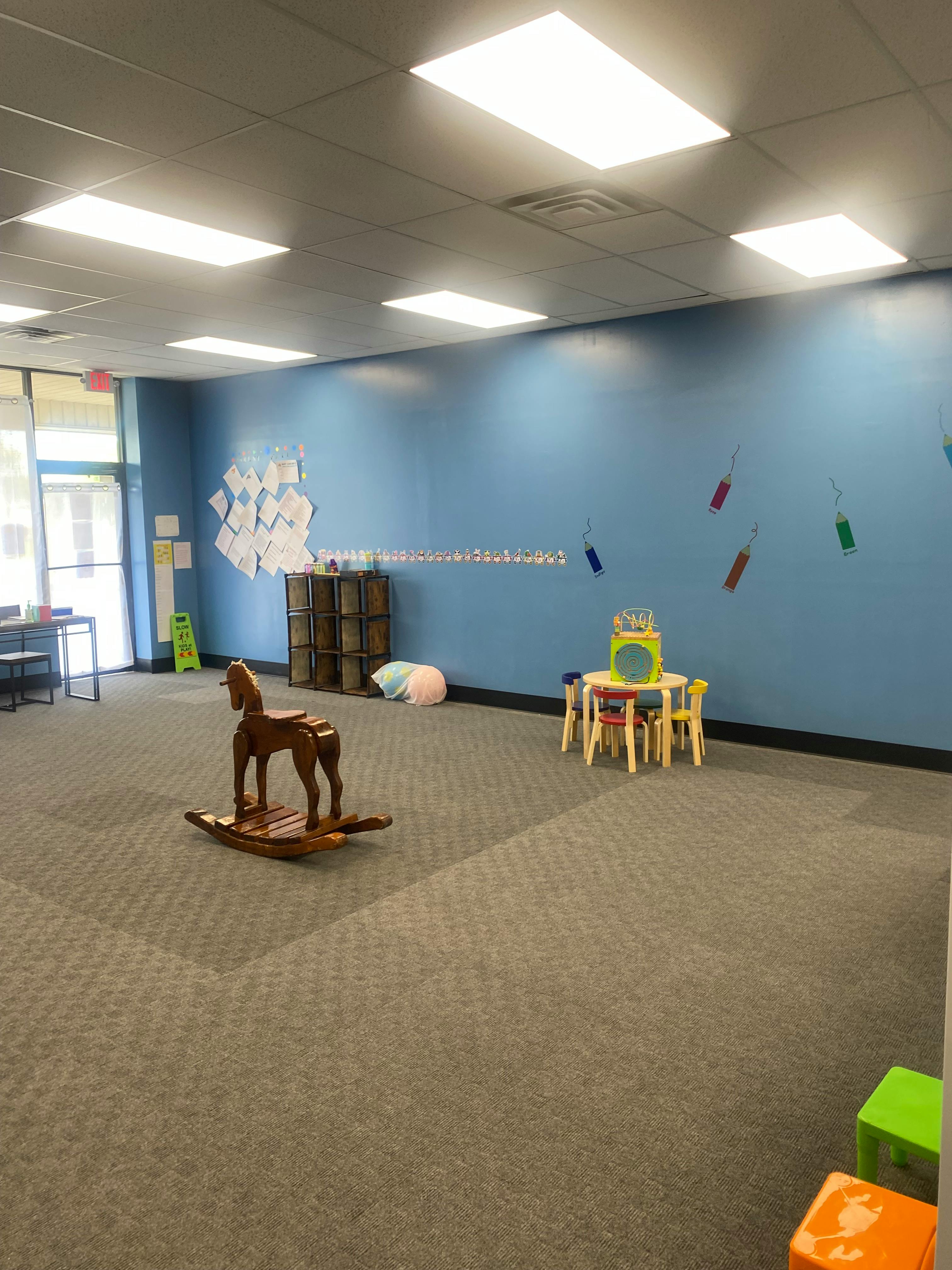Children's play area with a rocking horse and small table and chairs