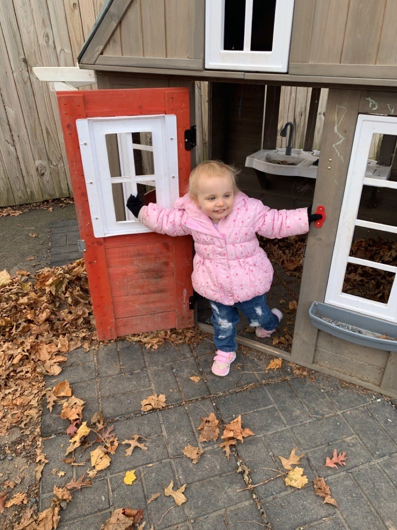 Child standing in a playhouse doorway
