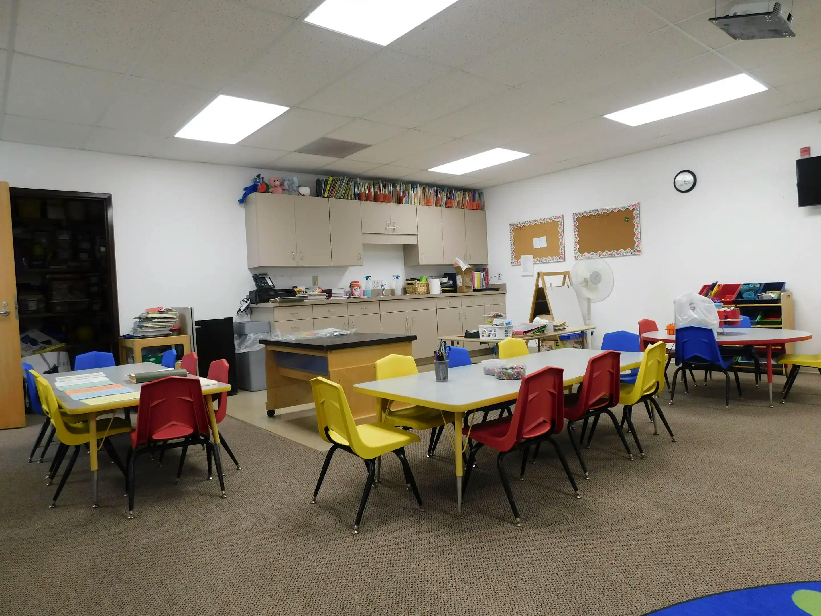 Classroom with small tables and chairs, and a counter area