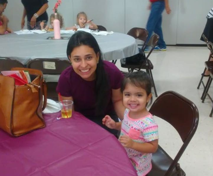 Person and child smiling at a table