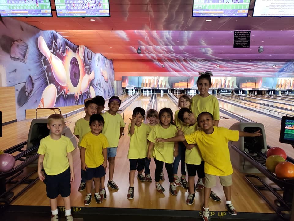 Group of children in yellow shirts at a bowling alley