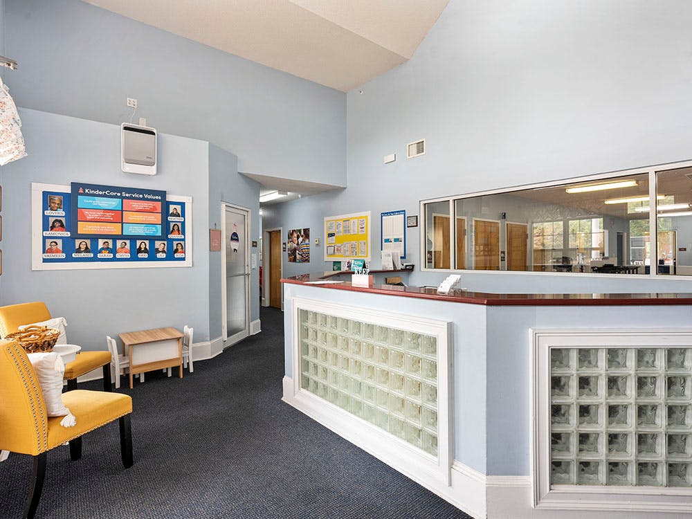 Reception area with a counter, glass block wall, and windows overlooking a room