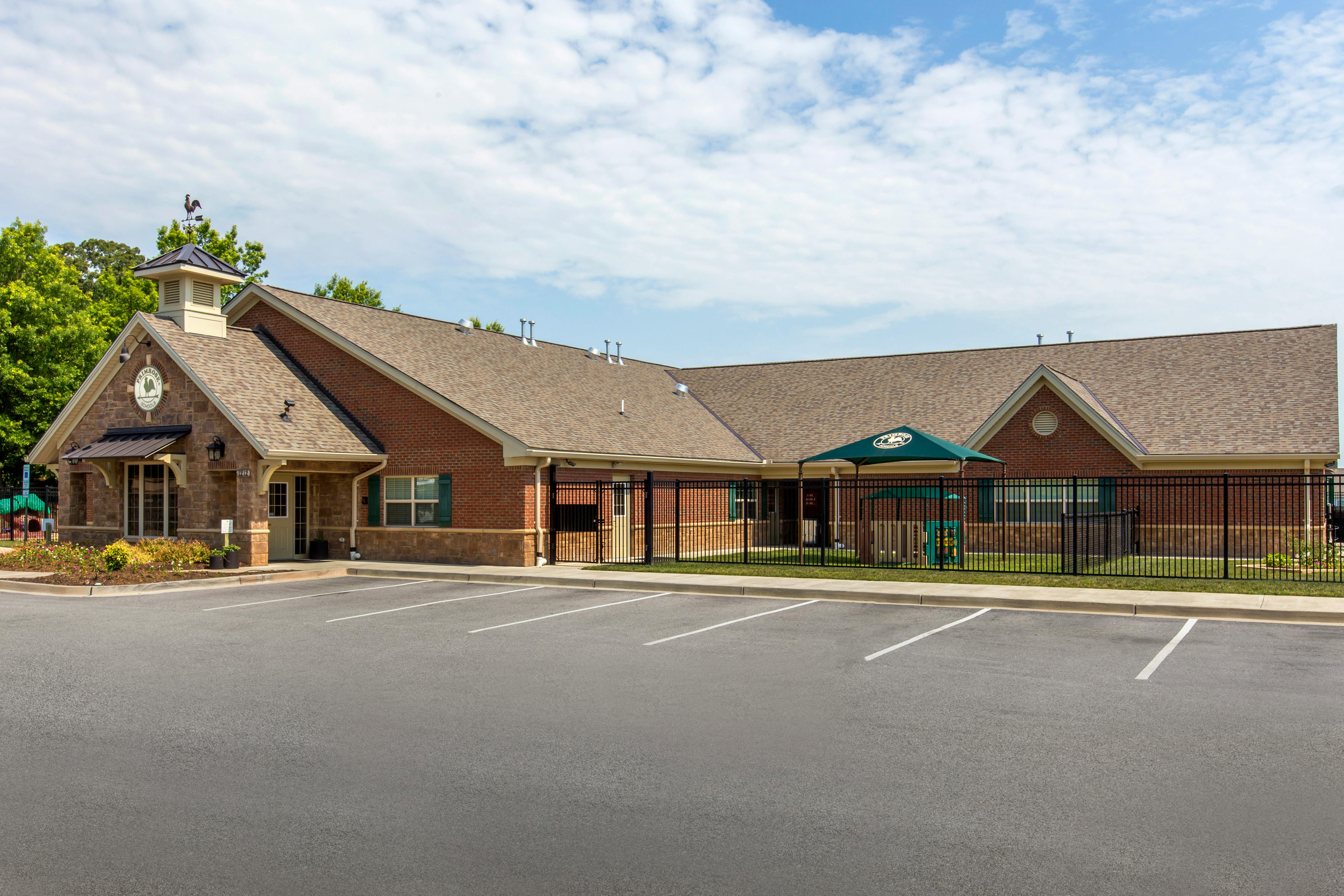 Building with a weather vane on the roof and a parking lot in the foreground