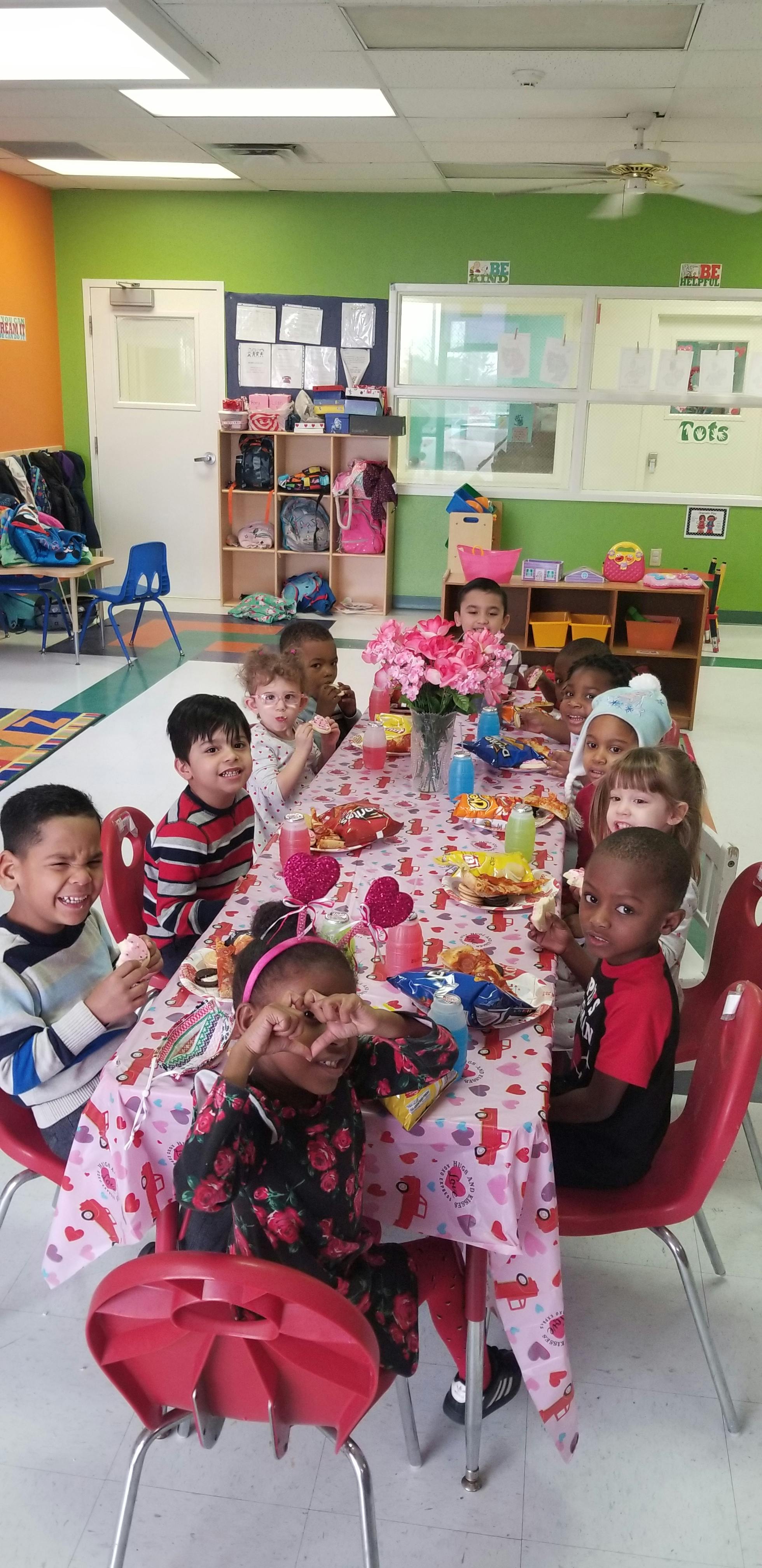 Children sitting at a table with snacks in a classroom