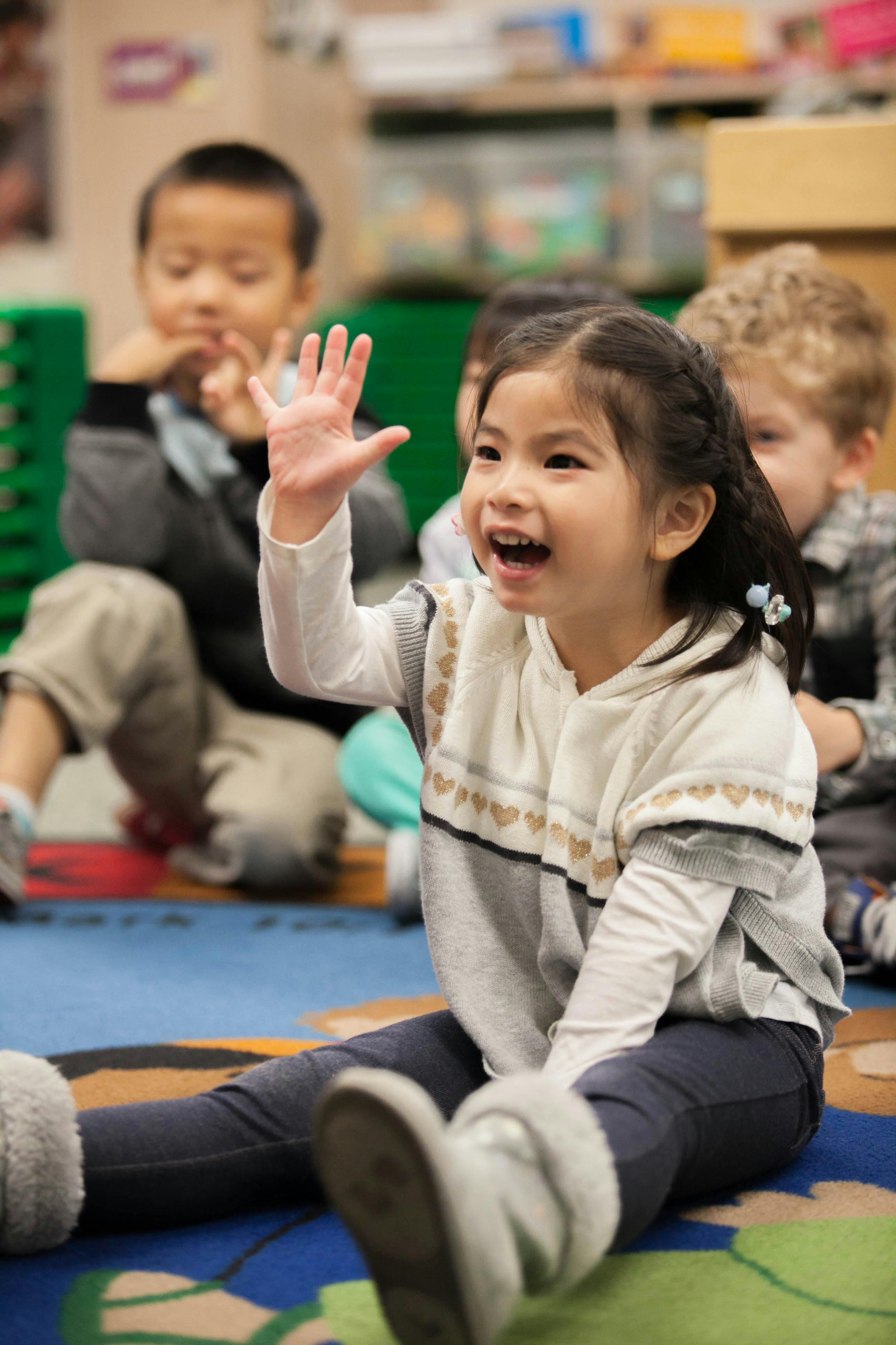 Child raising hand in a classroom